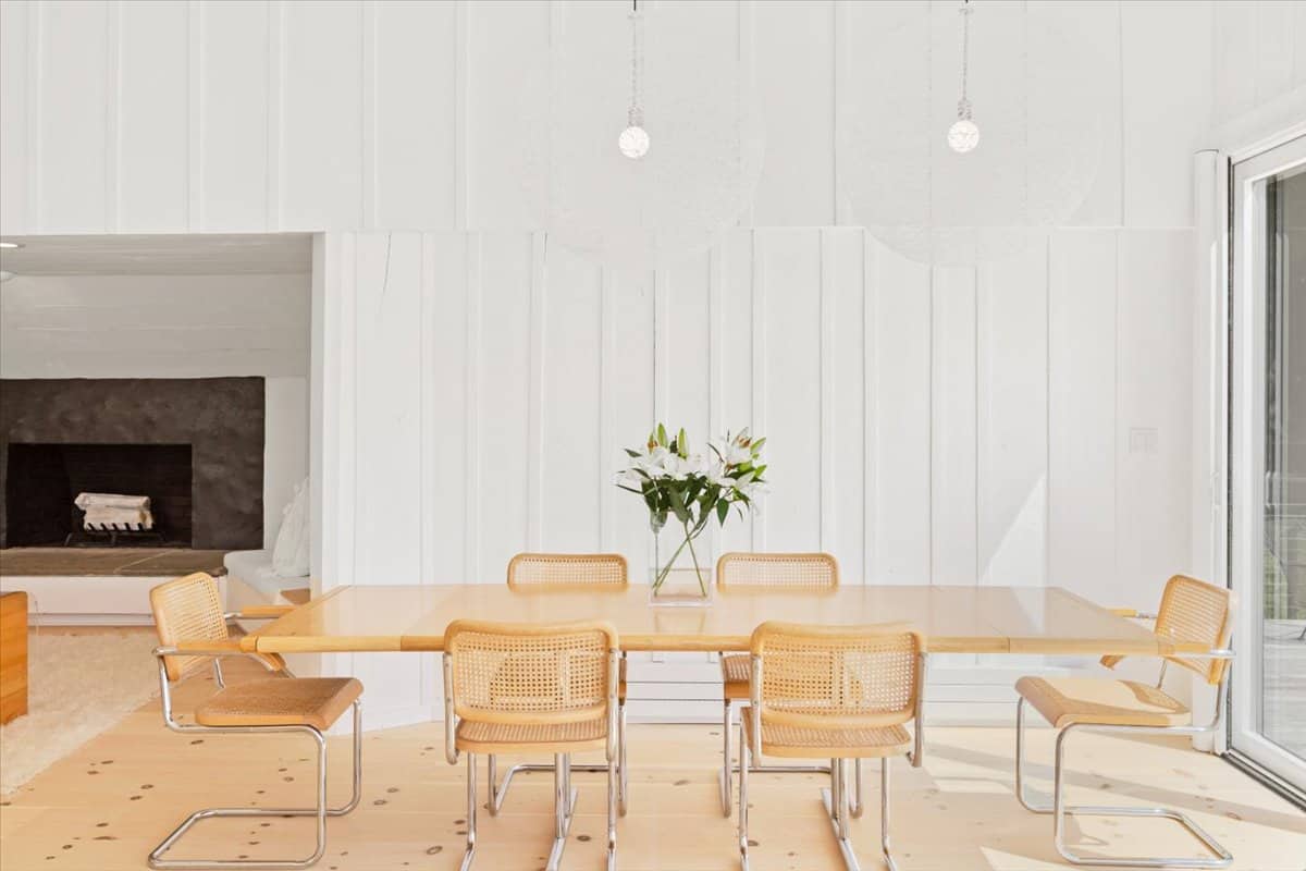 bright dining area inside the cottage with white walls and warm wood floors