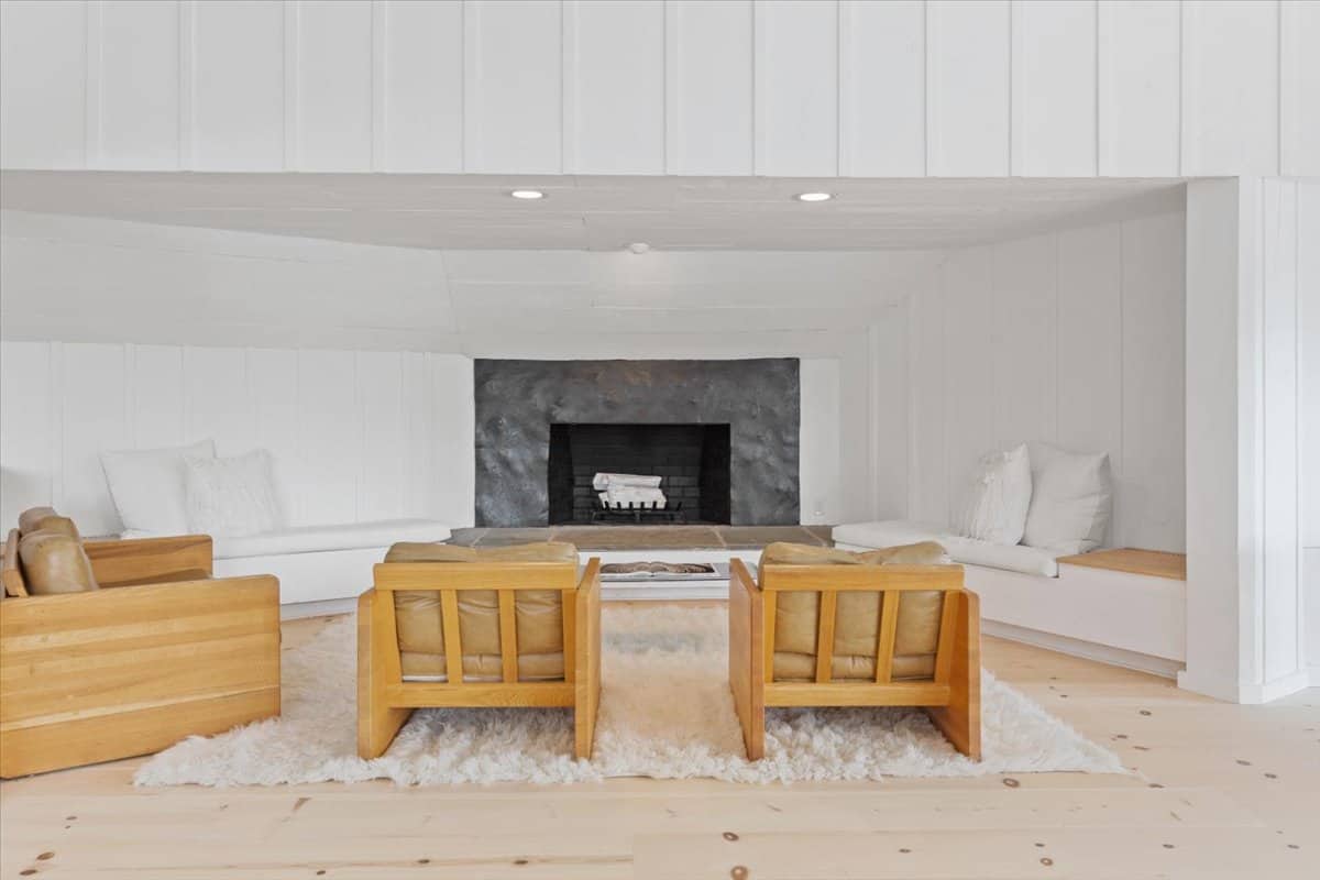 stone fireplace inside the cottage with white walls and warm wood floors