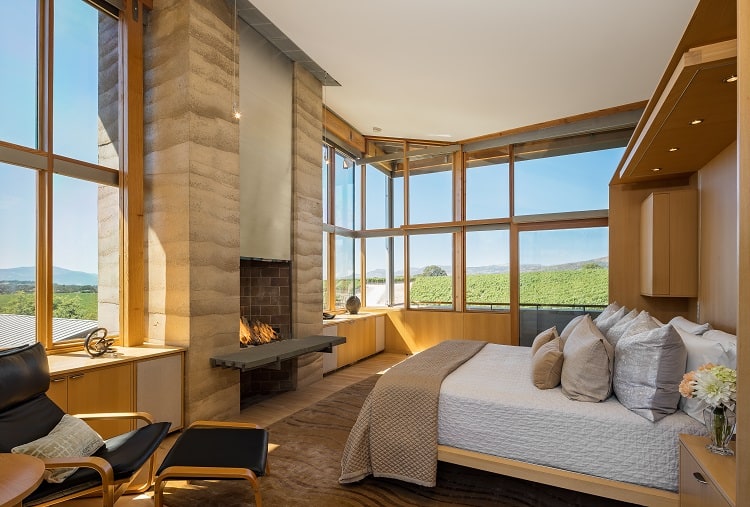 wood-clad bedroom with fireplace inside the Meteor Vineyard Estate