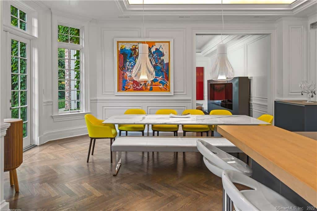 dining room with eye-grabbing art and yellow dining chairs