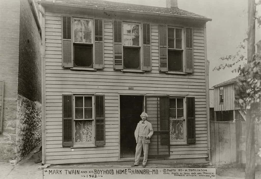 Author Mark Twain in front of boyhood home in Hannibal.