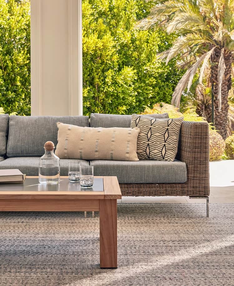 elegant outdoor sofa made out of wicker with throw pillows