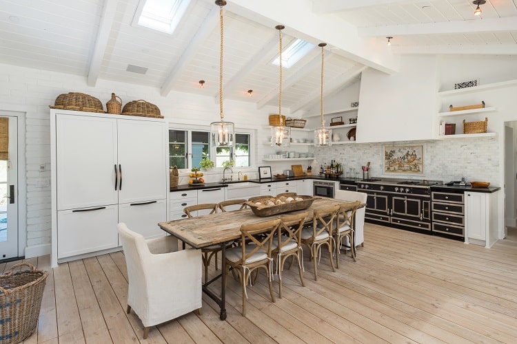 white kitchen with rustic elements, hanging lights, and high-end appliances