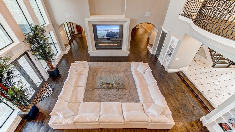 Luxurious living room with hardwood floors fireplace and large u-shaped sectional sofa