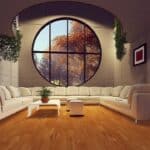 rendering of a luxury living room with a round window and u-shaped sectional sofa