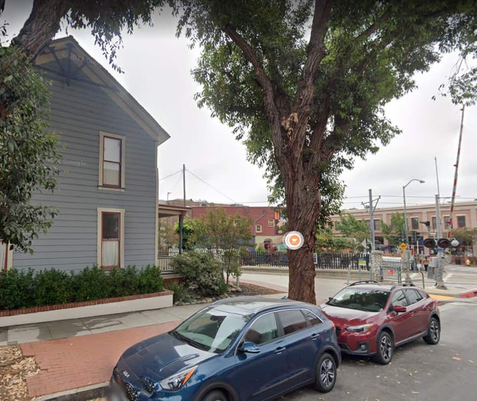 Sideview of house and its surroundings, with the Nichol's Hardware store across the street. 