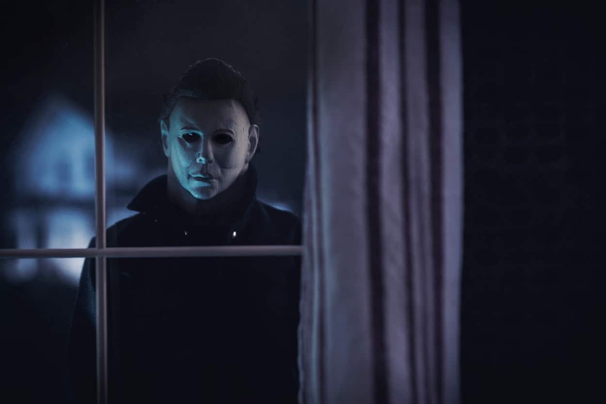 Halloween's Michael Myers looking through the window to see inside the house.