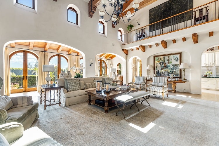 two-story living room with beam ceilings and picture windows inside Sugar Ray Leonard's house