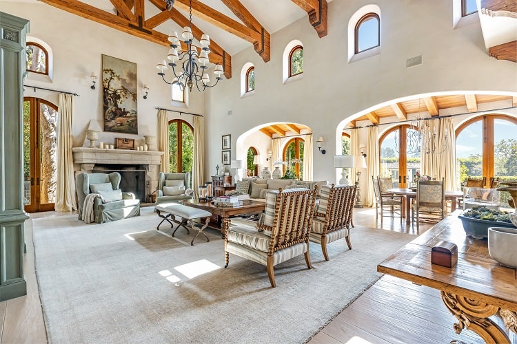 two-story living room with beam ceilings and picture windows inside Sugar Ray Leonard's house