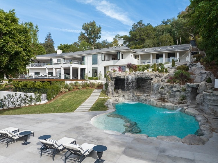 exterior of the house from the backyard showing the pool and grotto