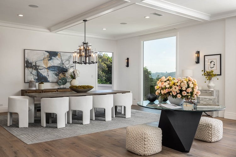 dining room with white chairs and intricate chandelier