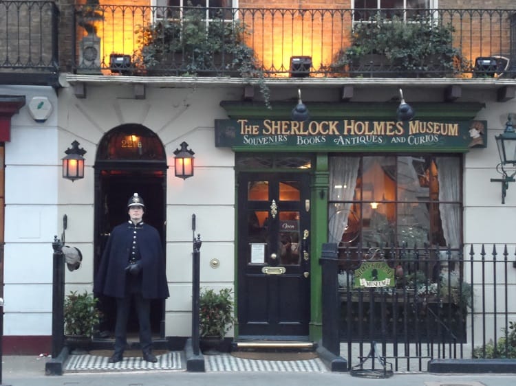 officer standing outside Sherlock Holmes' house and museum at his fictional address, 221B Baker St in London, UK.