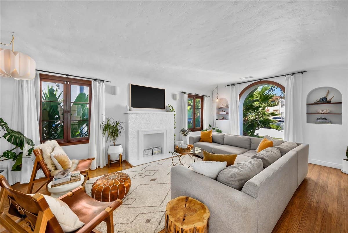 living room with white fireplace inside a Spanish bungalow