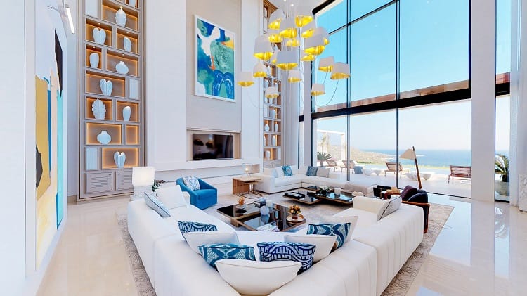 ultra-luxurious living room with white furniture and large windows with ocean views