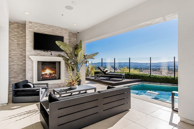 indoor-outdoor sitting area with a fireplace and flatscreen tv