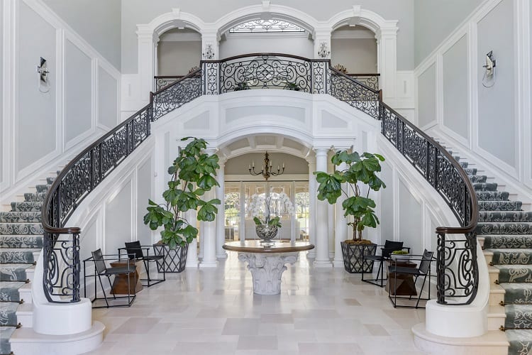 intricate staircase with rough iron railing leading upstairs