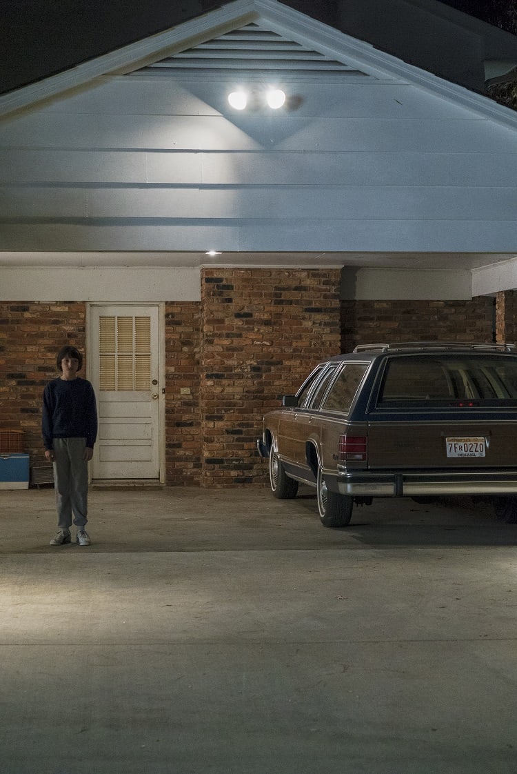 Mike standing in front of the Wheeler House in Stranger Things.