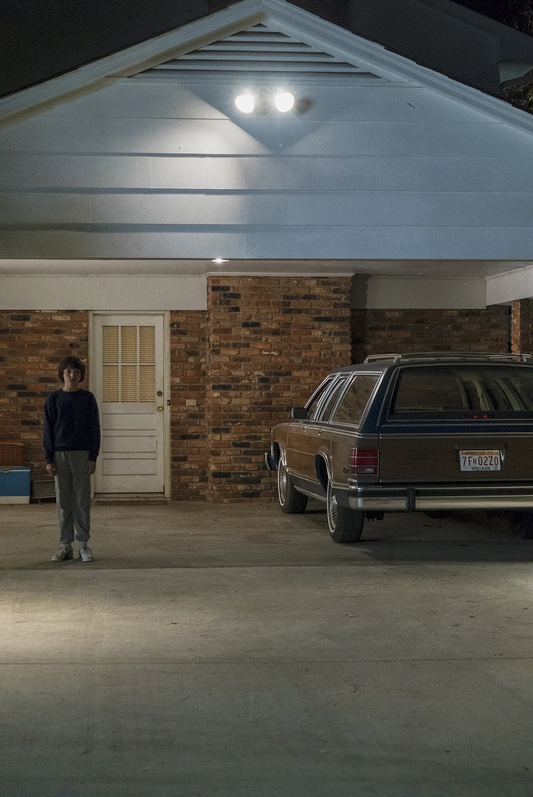 Mike standing in front of the Wheeler House in Stranger Things. 