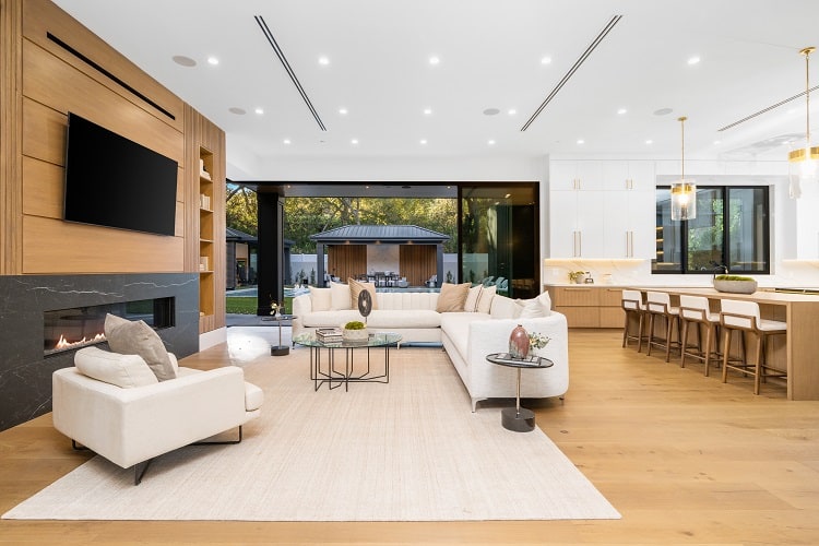 open floor plan living room and kitchen, with lots of warm wood and a fireplace