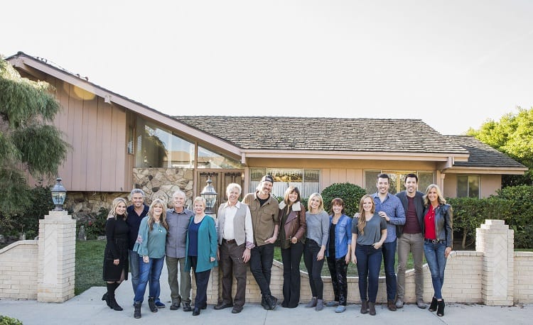 the original cast of The Brady Bunch posing in front of the house with the rest of the crew of A Very Brady Renovation