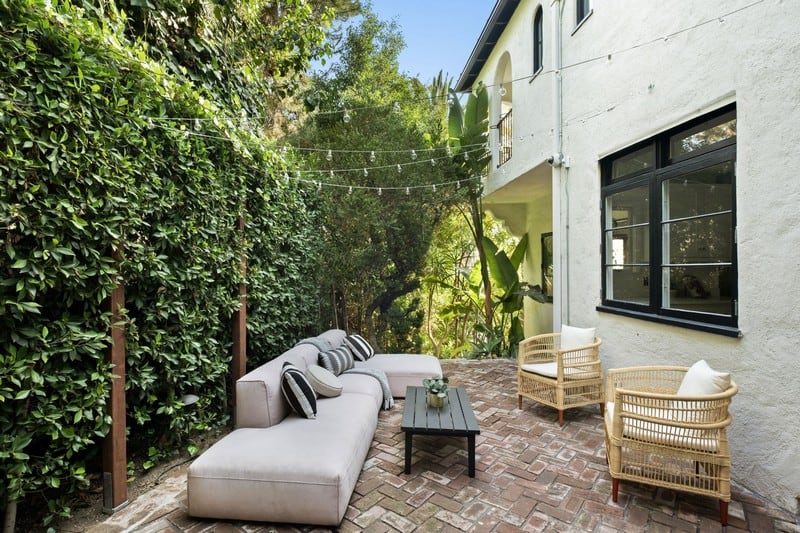 outdoor couch and seating area surrounded by greenery