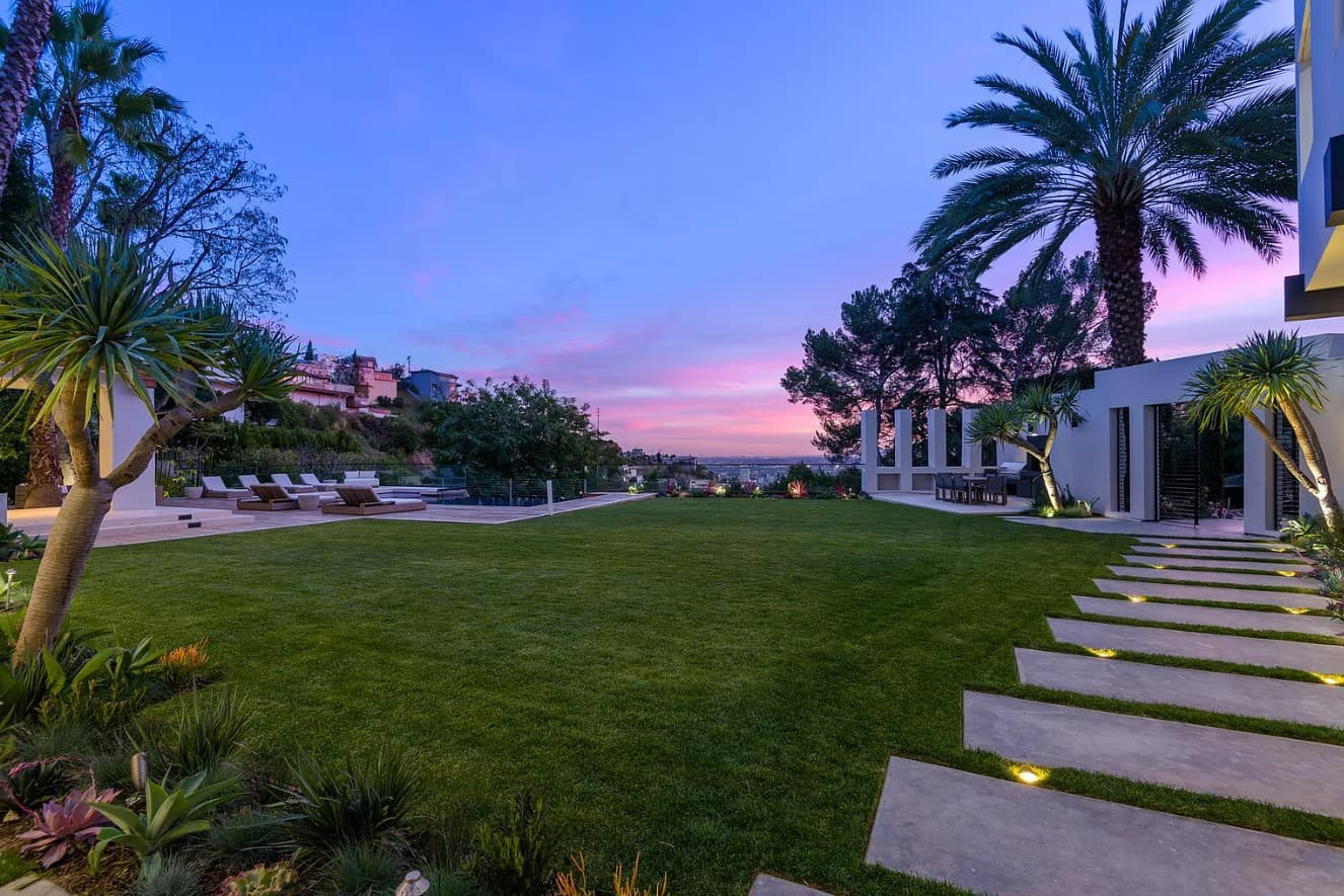 Backyard path with palm trees leading to the guesthouse in Bad Bunny's new house