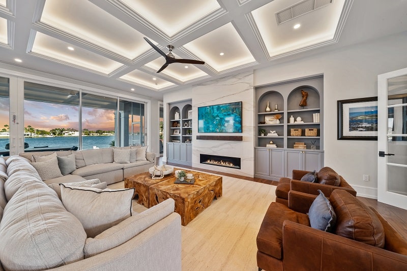 living room with coffered ceilings, ceiling fan, and fireplace