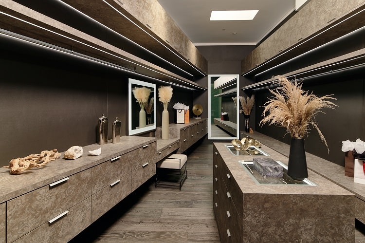 private closet room with dark brown furnishings and many drawers