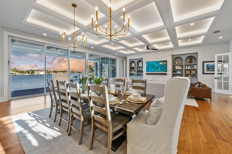 luxury dining room overlooking the living with sliding glass doors leading to the waterfont area