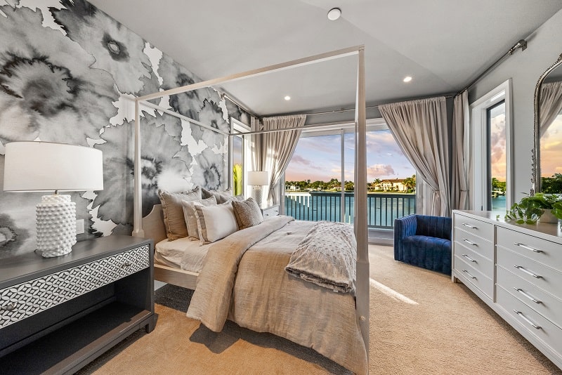 bedroom with interesting wallpaper, a four-posted bed, and large balcony