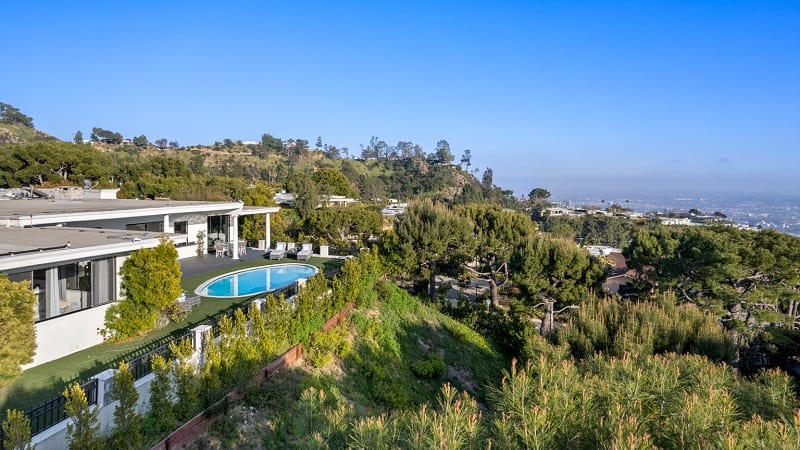 parts of the house with the pool in front and its city views extending over the canyon