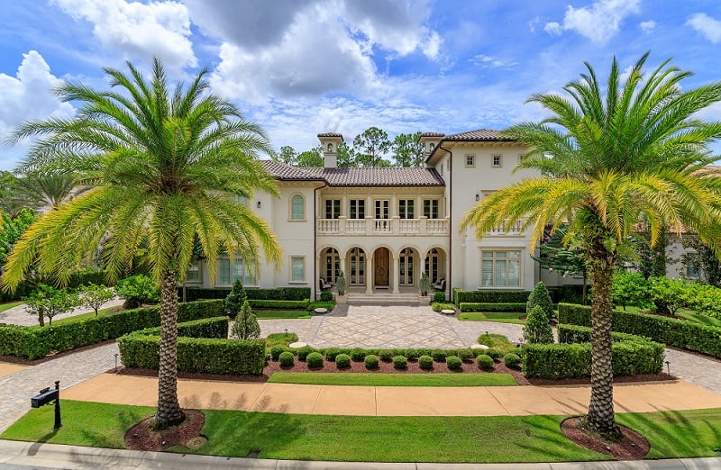 an Italianate mansion with landscaped driveway amid palm trees at Walt Disney World Orlando