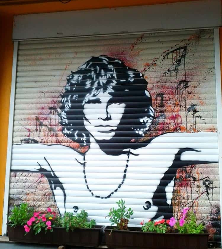 grafitti of jim morrison holding his hand out to the side