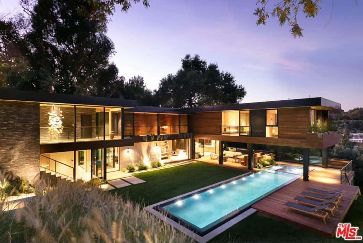 Lizzo's house in Los Angeles, seen at night, with lights turned on inside the house, and the pool lit