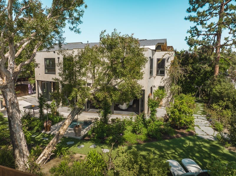 large two-story house hid behind tall trees