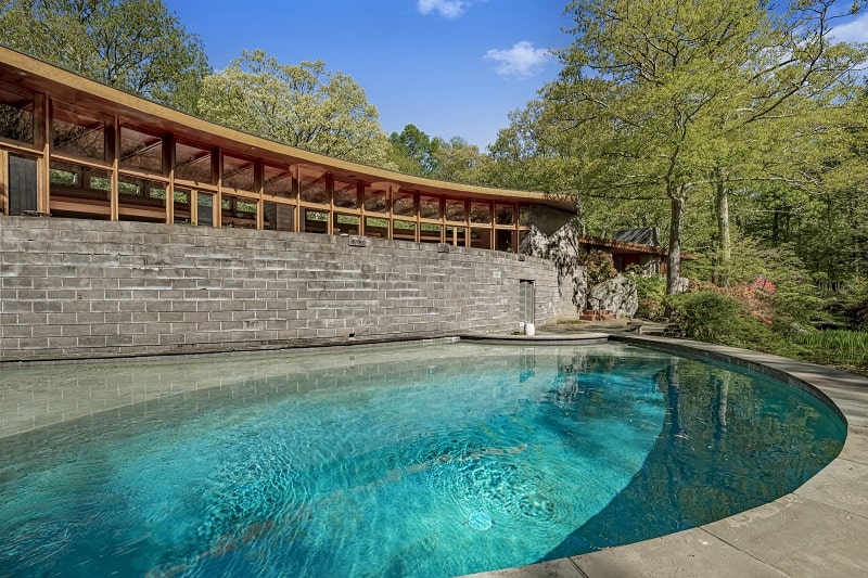 round pool filled with water next to a stone and wood structure