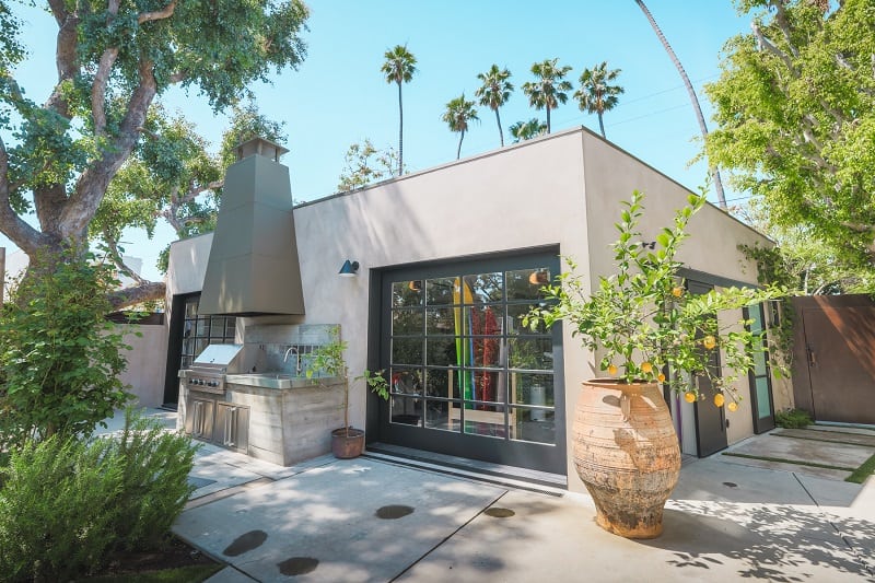 cute garage with a an outdoor kitchen and an orange tree in a ceramic planter