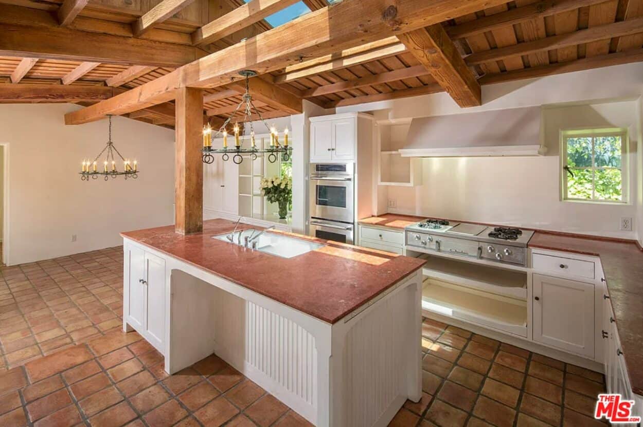 the kitchen inside Marilyn's house, boasting beamed wood ceiling and a large white kitchen counter