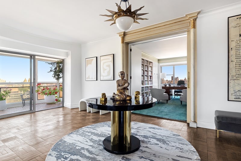 hallway with a round table at its center, with a buddha statue on it  