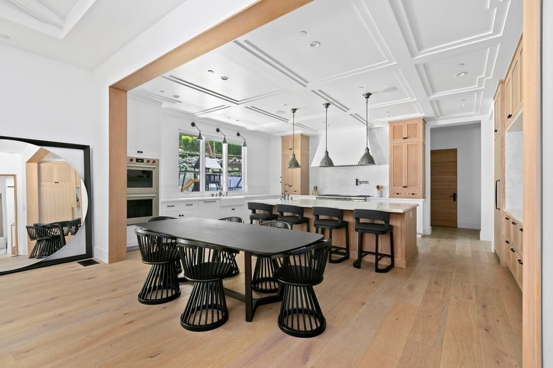 bright kitchen with a black dining area and warm wood furniture