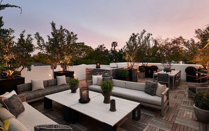 large rooftop deck with patio furniture and a dining table