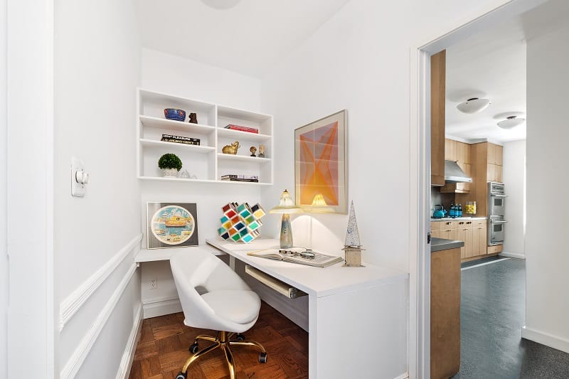 small study nook next to the kitchen with all-white furniture