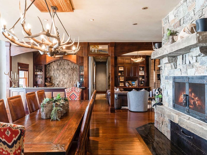 rustic interiors with a rock fireplace, lots of wood, and an antler chandelier