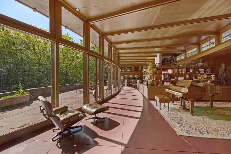 mid-century interiors with large wood paneling, floor-to-ceiling windows and a wooden piani