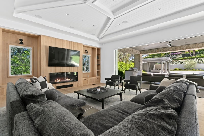 large living room with wood panels, TV, fireplace and large sofa