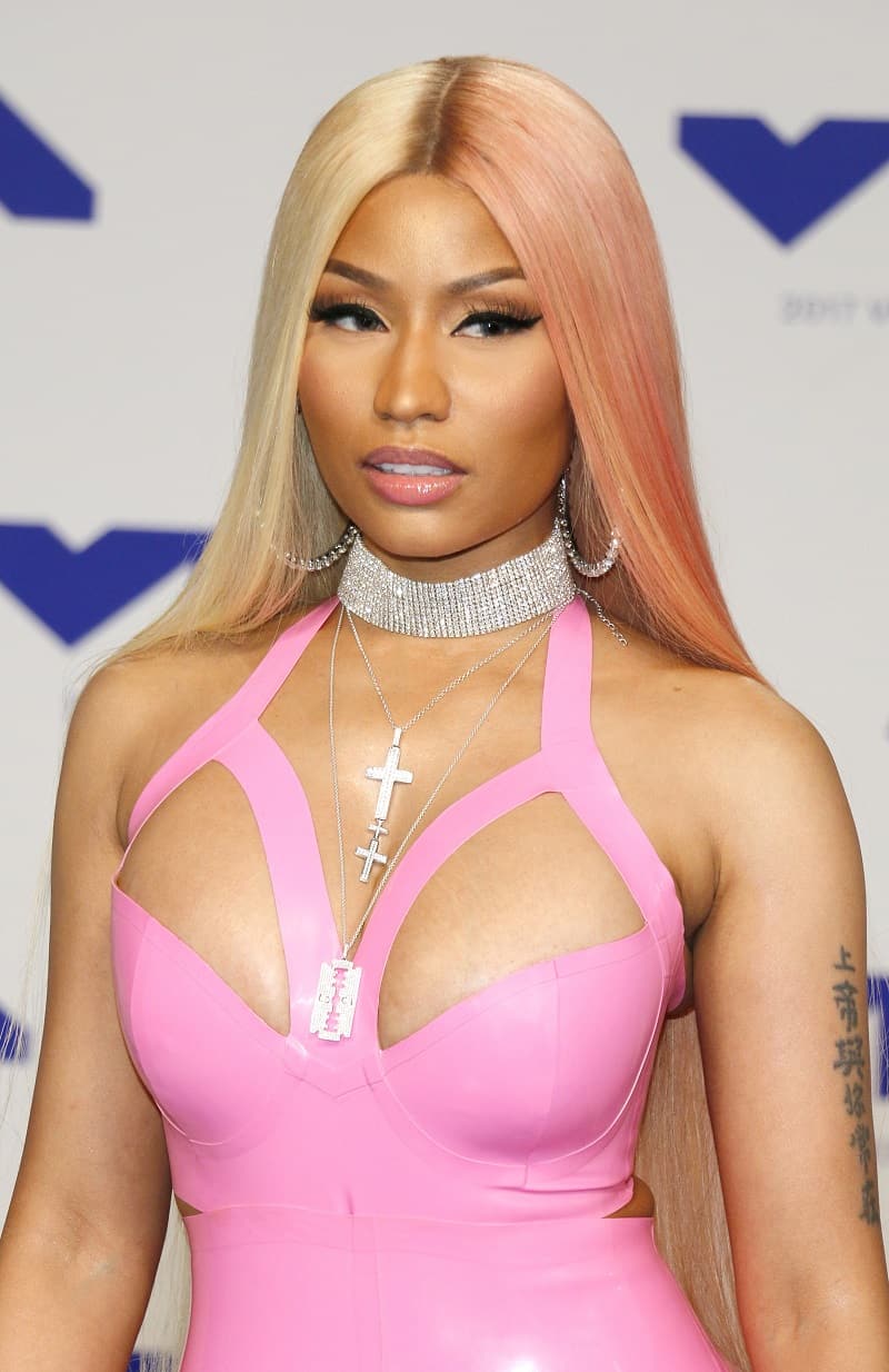 rapper Nicki Minaj on the red carpet wearing a bright pink latex suit and lots of jewerly 