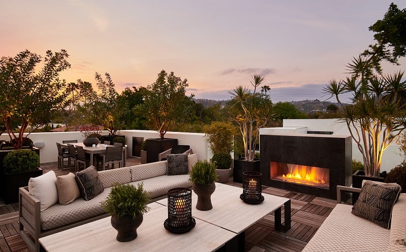 large rooftop deck with patio furniture and a fireplace