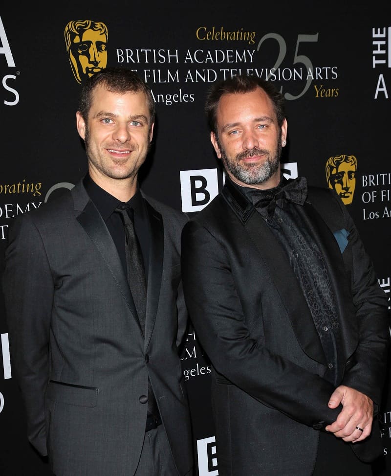 South Park creators Matt Stone and Trey Parker on the red carpet wearing all-black suits and ties