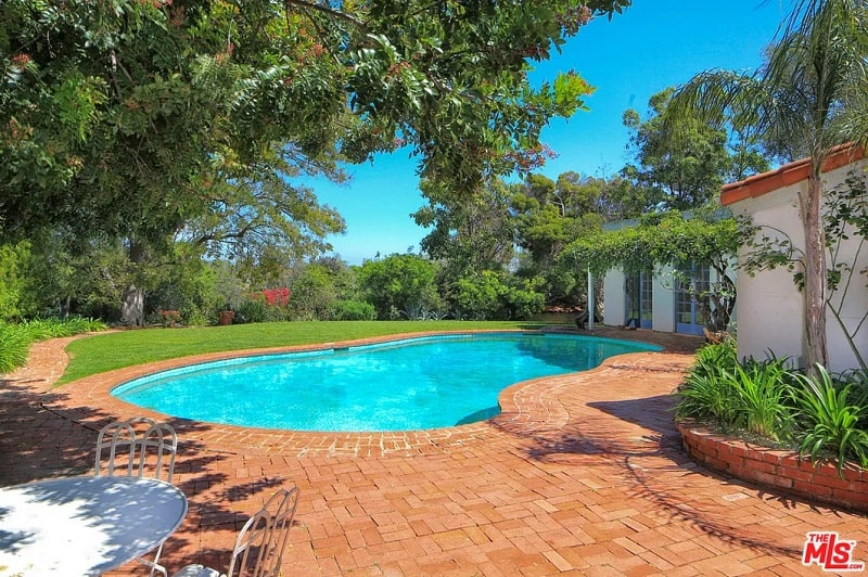 The backyard Marilyn's home, featuring a small pool and brick patio