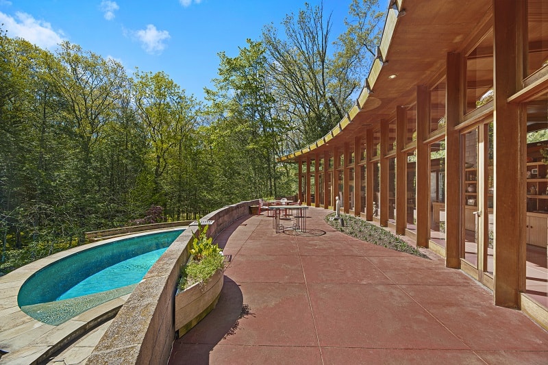 circular pool and an outdoor patio outside the Tirranna House, with columns supporting the structure